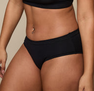Close up view of Jade wearing the Cloud Cotton Hiphugger in Black. The minimal seams and soft cotton modal fabric are emphasized.