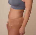 Side profile of model Sonnie in the Cloud Cotton Hiphugger in Dune. The image shows the soft leg seams and low-rise front for comfortable, everyday wear.