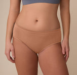 Close-up of the Cloud Cotton Hiphugger in Dune on model Sonnie. The image focuses on the mid-rise waistband and smooth front panel made from ultra-soft cotton modal fabric.