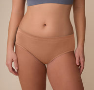 Close-up of the Cloud Cotton Hiphugger in Dune on model Sonnie. The image focuses on the mid-rise waistband and smooth front panel made from ultra-soft cotton modal fabric.