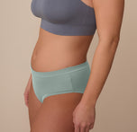 Side profile of model Sonnie in the Cloud Cotton Hiphugger in Seaglass. The image shows the soft leg seams and low-rise front for comfortable, everyday wear.