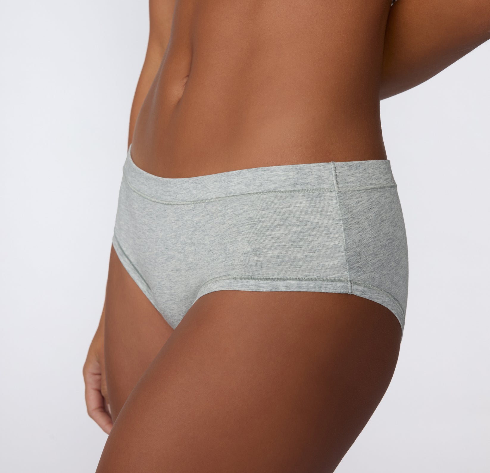 Angled side view on a light studio backdrop of the Cloud Cotton Hiphugger in Light Heather Grey, highlighting the hip-hugging fit and soft cotton modal fabric.