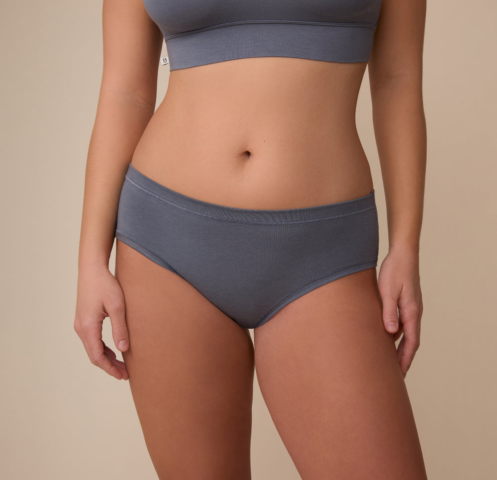 Front view of Sonnie wearing the Cloud Cotton Hiphugger in Slate. The image showcases the hip-hugging cut and soft ribbed texture, sitting comfortably just below the waist. sizing: Sonnie wears size Large
