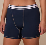 Close-up of the Cloud Cotton Retro Boxer Brief in Midnight, worn by Sonnie. The image focuses on the soft, stretch waistband with Harper Wilde branding and ergonomic seam construction.