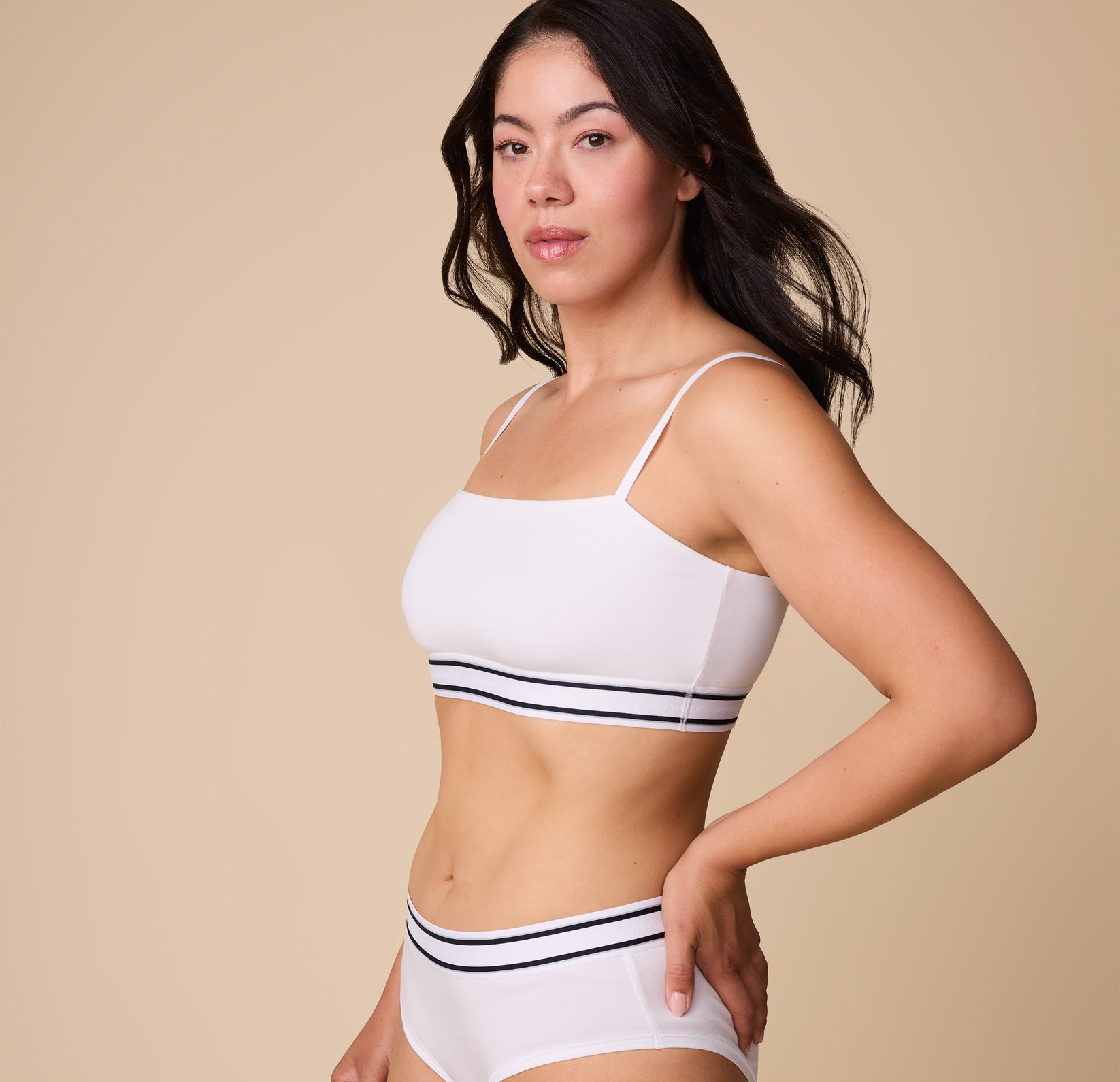A three quarter profile of Emersyn in the Cloud Cotton Retro Bandeau Bralette in White, showcasing the soft, breathable cotton fabric and flexible fit.