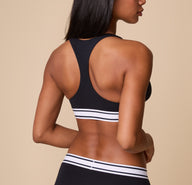 The back view of Ally wearing the  Cloud Cotton Retro Racerback Bralette in Black, highlighting the racerback design for extra support and freedom of movement.
