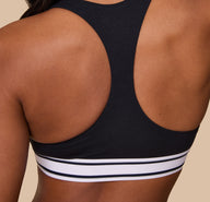 A close-up of the racerback feature of the Cloud Cotton Retro Racerback Bralette in Black, showing the contouring fit and breathable cotton texture.