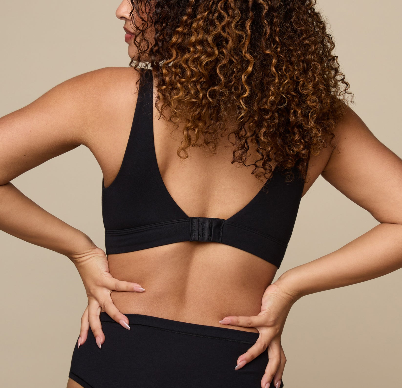 Back view of Jade in the Cloud Cotton Scoop Bralette in Black, highlighting the deep scoop back and hook-and-eye closure at the band for a customizable fit.