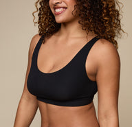 Close-up of Jade in the Cloud Cotton Scoop Bralette in Black, focusing on the neckline and supportive fit. The image captures the brushed cotton texture and clean finish.