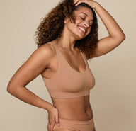 Three quarter view of Jade wearing the Cloud Cotton Scoop in Dune. The scoop neckline and ultra-soft cotton modal fabric are emphasized. 