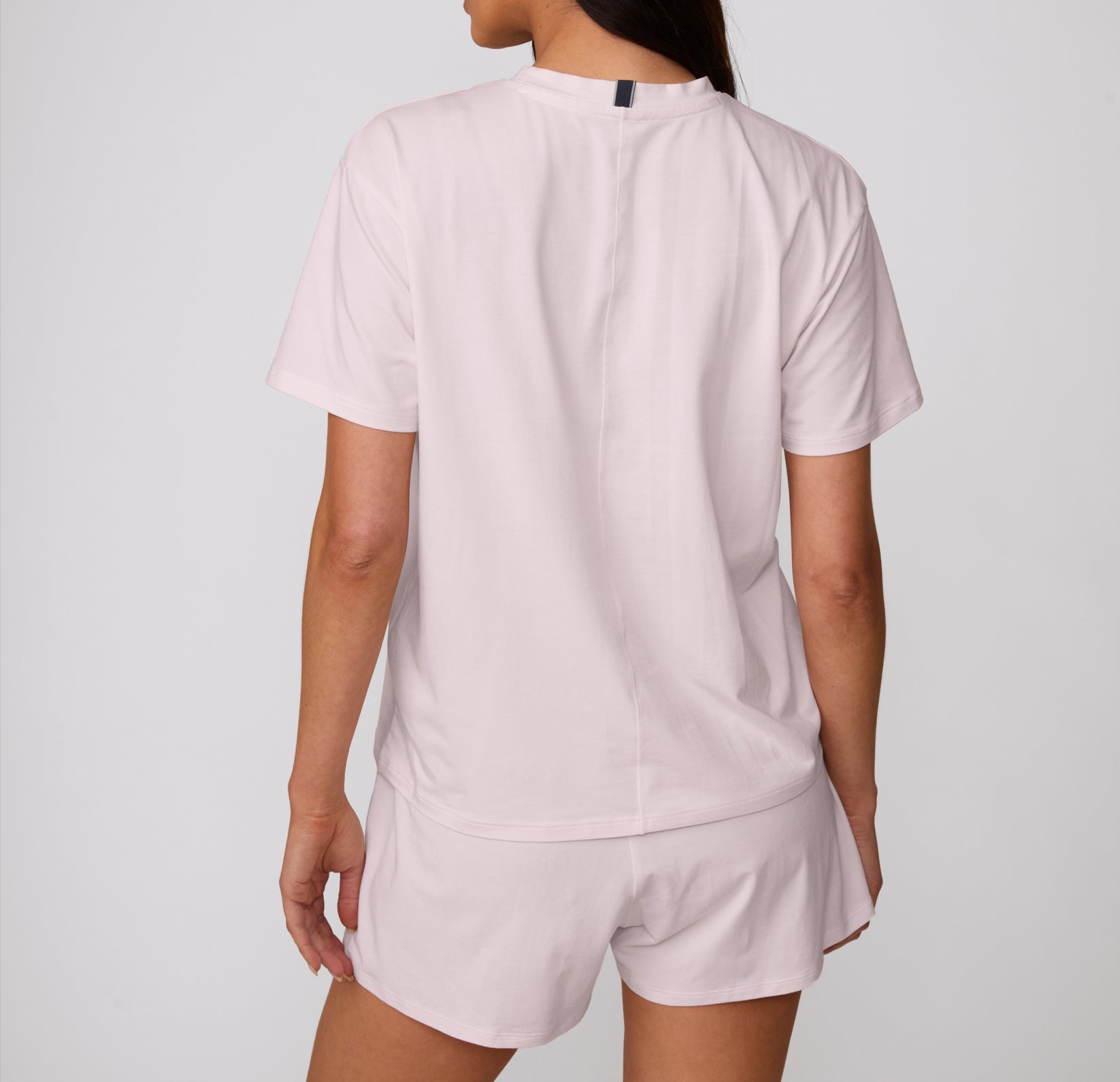 On a clean studio backdrop, a back view shows a model wearing the Cloud Cotton Short in Primrose with the Cloud Cotton Tee, featuring a relaxed fit and soft cotton modal fabric.