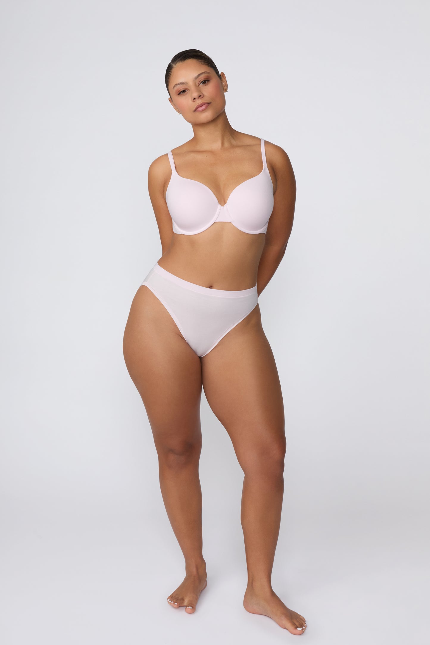 On a white studio backdrop, India stands in a full-body front view wearing the Cloud Cotton T-Shirt Bra in Primrose with the matching Cloud Cotton brief, showing the smooth molded cups, scoop neckline, and everyday silhouette.