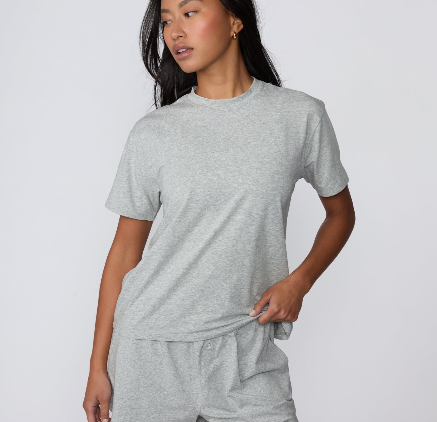 On a white studio backdrop, the Cloud Cotton Tee in Heather Grey is shown from the front, featuring a classic crew neckline and short sleeves in soft cotton modal fabric.