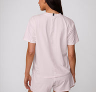 On a clean studio backdrop, a back view shows a model wearing the Cloud Cotton Tee in Primrose, featuring the relaxed fit and smooth cotton modal fabric.