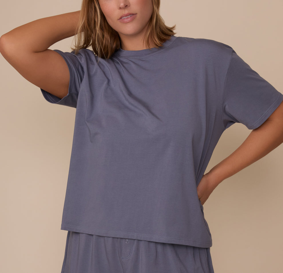 Sonnie wearing the Cloud Cotton T-Shirt in Slate. She has one arm bent behind her head, highlighting the relaxed sleeve fit and breathable cotton-modal fabric. sizing: Sonnie wears size XL