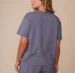 Back view of Sonnie wearing the Cloud Cotton T-Shirt in Slate. The image shows the shirt’s center seam detail and loose, easygoing fit across the back and shoulders.