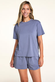 In a softly lit studio, Meagan wears the Cloud Cotton Tee and Cloud Cotton Short in Slate. The relaxed-fit tee features short sleeves and soft cotton modal fabric, paired with matching lounge shorts designed for easy everyday comfort.