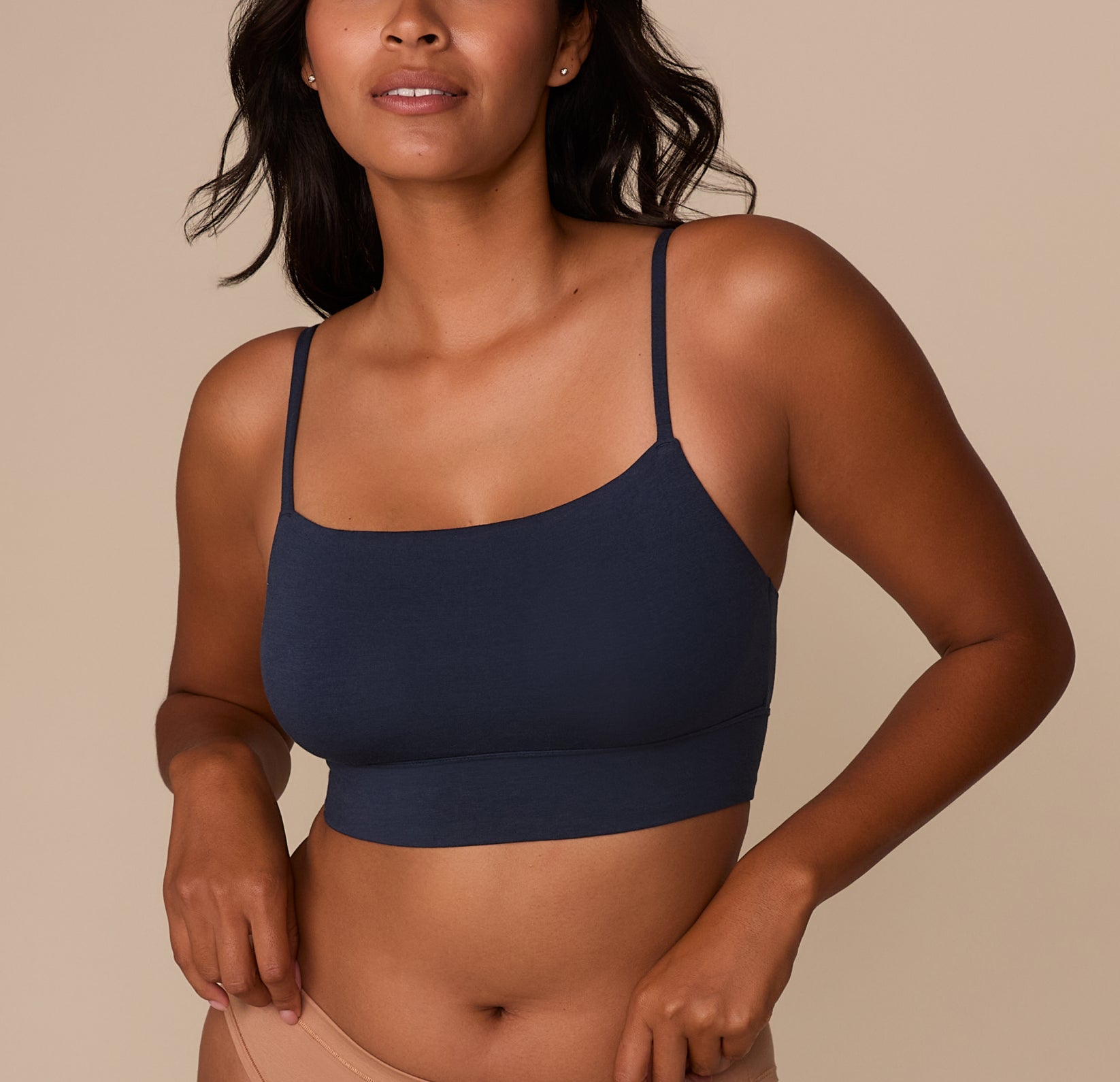 Victoria wearing the Cloud Cotton Thin Strap Bralette in Midnight, shown from the front. The bralette features a scoop neckline, thin adjustable straps, and a longline body in a soft cotton-modal blend. sizing: Victoria wears size Medium