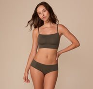 Full-body view of Alexis wearing the Cloud Cotton Thin Strap Bralette in Olive with the matching Hiphugger, standing in a relaxed pose.