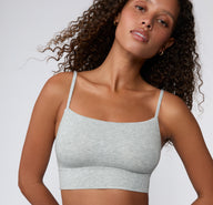 On a light studio backdrop, the Cloud Cotton Thin Strap Bralette in Light Heather Grey is shown from the front on a model, highlighting the square neckline, thin straps, and soft cotton modal fabric.