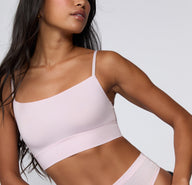 On a clean studio backdrop, a model wears the Cloud Cotton Thin Strap Bralette in Primrose, featuring a soft square neckline, thin adjustable straps, and a longline band made from cotton modal fabric for everyday comfort.