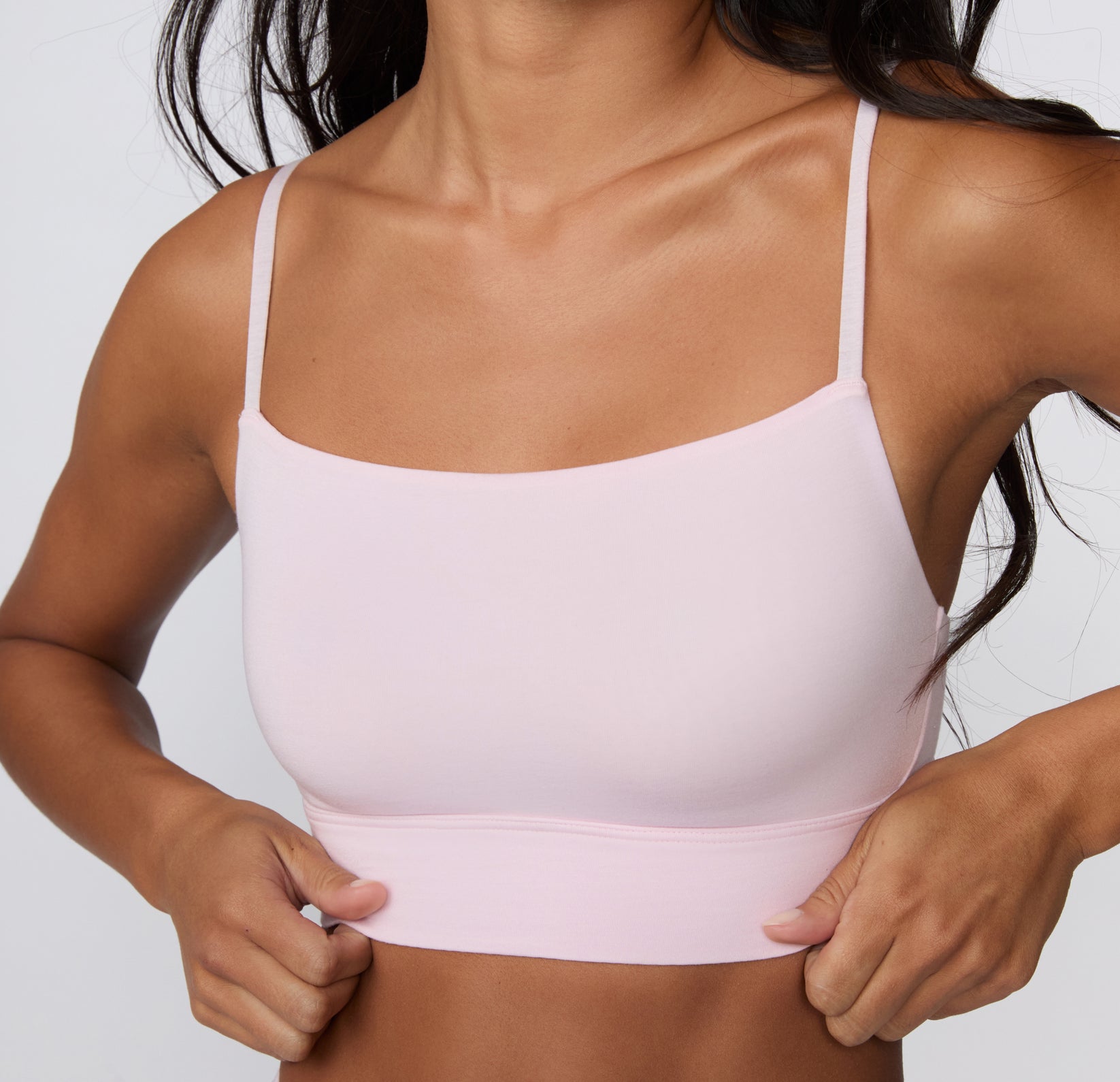 On a clean studio backdrop, a close-up shows a model wearing the Cloud Cotton Thin Strap Bralette in Primrose, highlighting the soft square neckline, thin adjustable straps, and smooth longline cotton modal band.