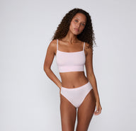 On a clean studio backdrop, a full-body view shows a model wearing the Cloud Cotton Thin Strap Bralette in Primrose with matching underwear, highlighting the soft square neckline, thin adjustable straps, and longline cotton modal band. sizing: Courtney wears size Small
