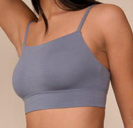 Angled close-up of the Cloud Cotton Thin Strap Bralette in Slate worn by Nemesis, focusing on the contouring fit and soft, stretchy cotton material.
