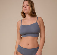 Sonnie wears the Cloud Cotton Thin Strap Bralette in Slate with a soft smile. The bralette features a clean neckline and thin straps, designed for cloud-like comfort. sizing: Sonnie wears size Large