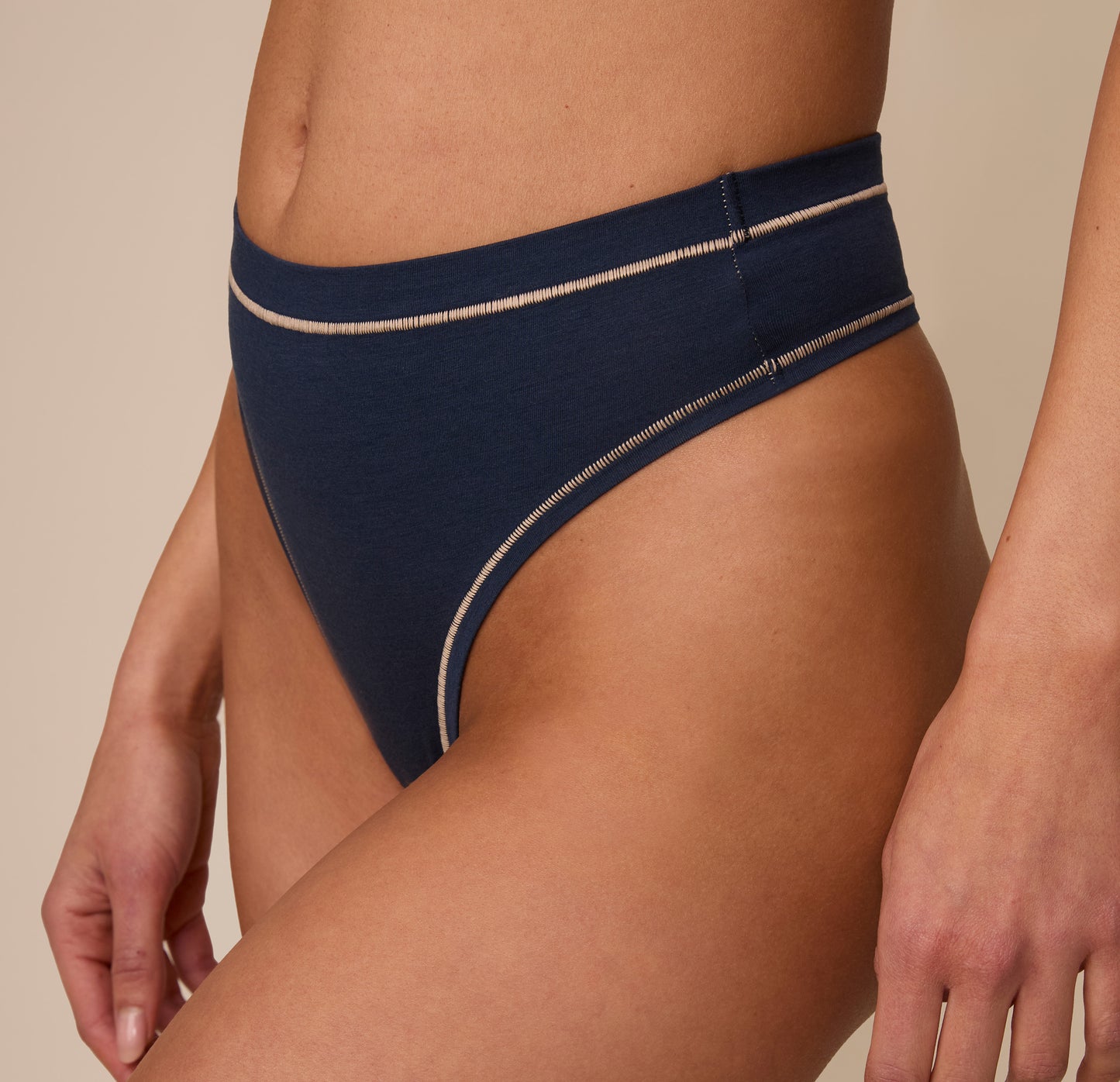 Side close-up view of Marcela wearing the Cloud Cotton Highwaist Thong in Midnight. This shot draws attention to the minimal seam side construction and soft-stretch fabric along the hip.