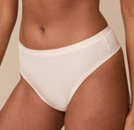 Close-up of the Cloud Cotton Thong in Quartz worn by model Victoria. The image draws attention to the minimal seam construction and ultra-soft feel of the fabric.