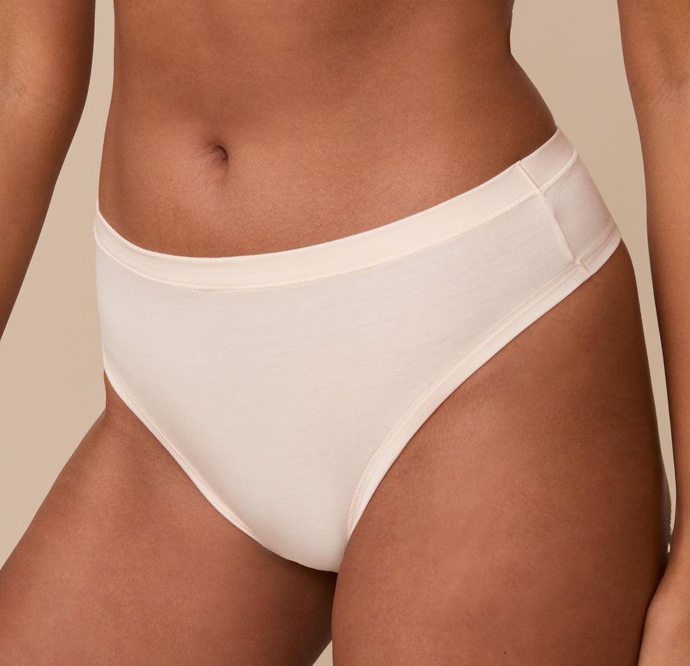 Close-up of the Cloud Cotton Thong in Quartz worn by model Victoria. The image draws attention to the minimal seam construction and ultra-soft feel of the fabric.