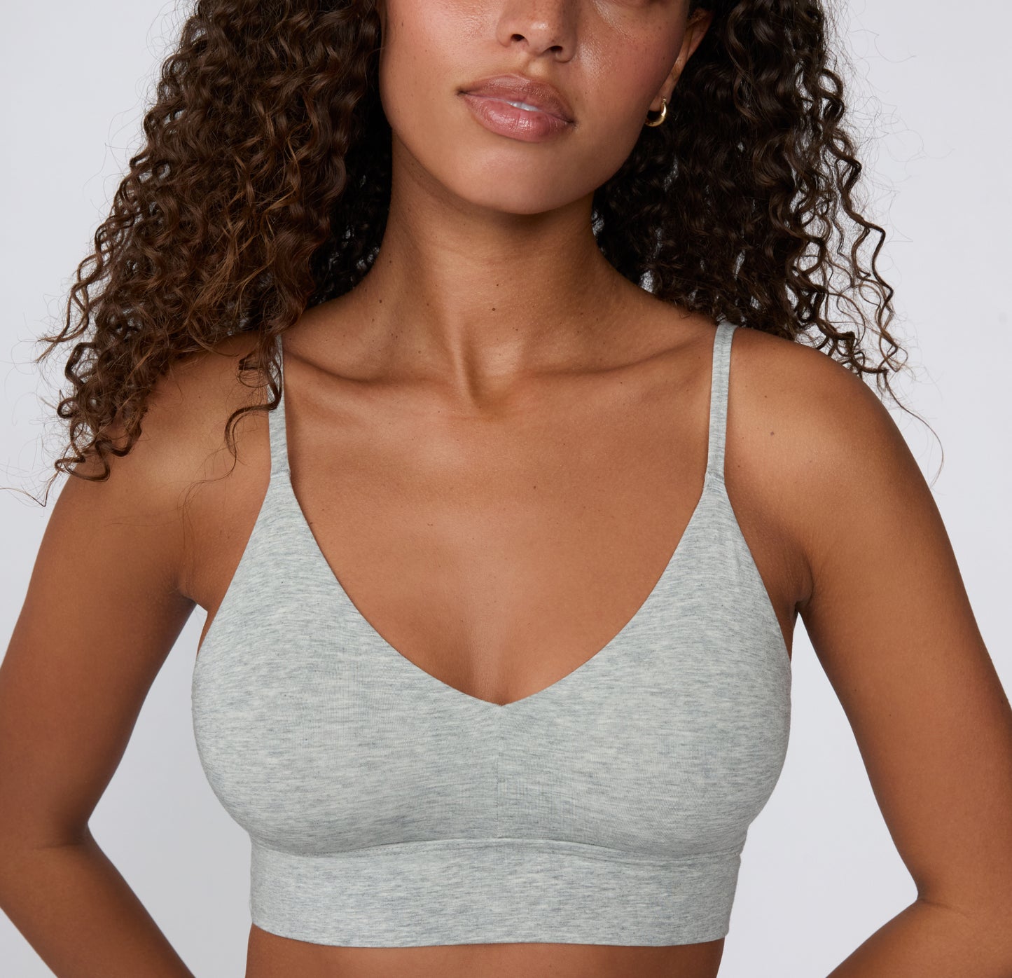 On a clean studio backdrop, a model wears the Cloud Cotton Triangle Bralette in Heather Grey, highlighting the soft V-neckline, smooth cotton-modal fabric, and longline underband.