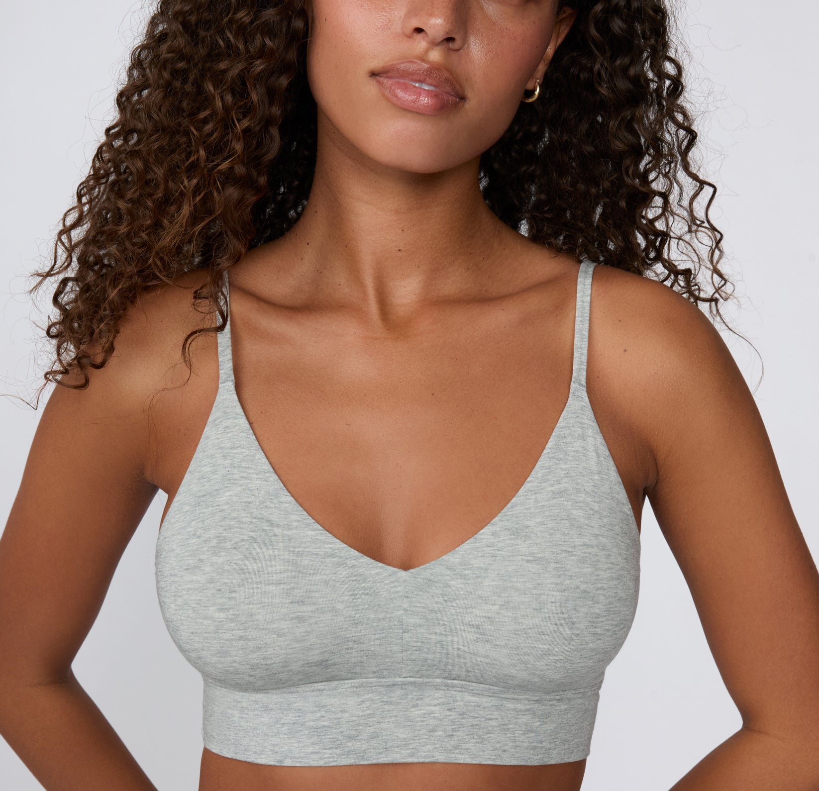 On a clean studio backdrop, a model wears the Cloud Cotton Triangle Bralette in Heather Grey, highlighting the soft V-neckline, smooth cotton-modal fabric, and longline underband.