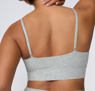On a white studio backdrop, a back view shows the Cloud Cotton Triangle Bralette in Heather Grey, highlighting the straight back silhouette, adjustable straps, and wide, comfortable underband.