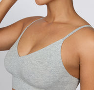 On a light studio background, a close-up shows the Cloud Cotton Triangle Bralette in Heather Grey, highlighting the soft V-neckline, smooth cotton-modal fabric, and lightweight, wireless construction.