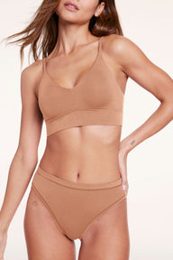 Close-up of Linni wearing the Cloud Cotton Triangle Bralette and Cloud Cotton French Cut underwear in Dune, featuring a soft V-neckline, adjustable straps, and lightweight cotton modal fabric. sizing: Linni wears size Small