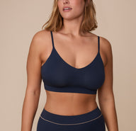 Sonnie wearing the Cloud Cotton Triangle Bralette in Midnight. The low v-neck neckline and thin straps are emphasized. sizing: Sonnie wears size XL
