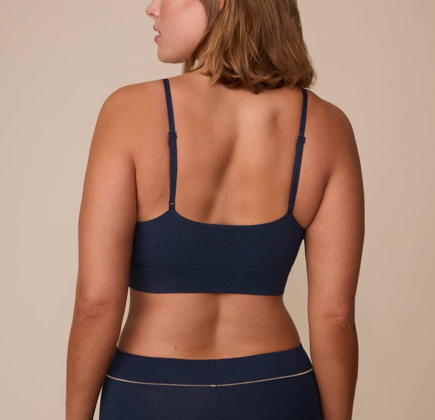 Sonnie wearing the Cloud Cotton Triangle Bralette in Midnight. The thin adjustable straps and wide smooth back panel are emphasized. 
