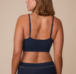 Sonnie wearing the Cloud Cotton Triangle Bralette in Midnight. The thin adjustable straps and wide smooth back panel are emphasized. 