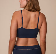 Sonnie wearing the Cloud Cotton Triangle Bralette in Midnight. The thin adjustable straps and wide smooth back panel are emphasized. 