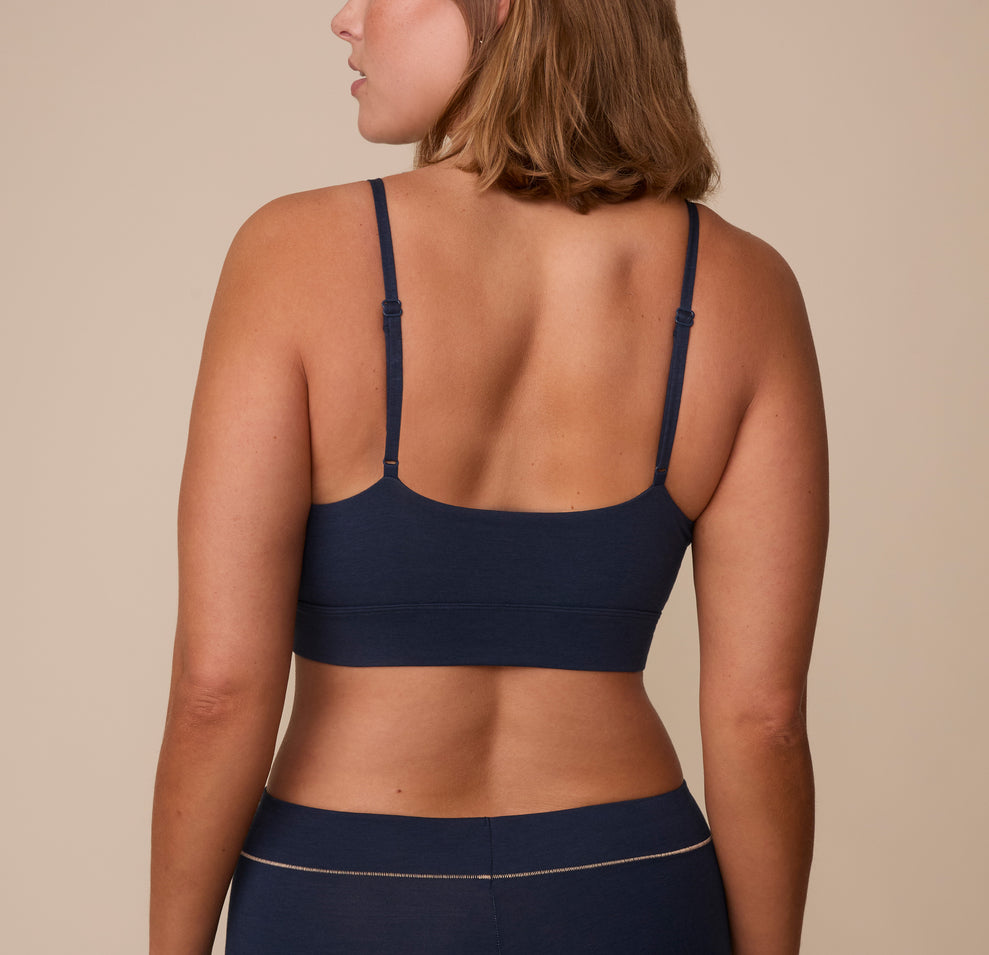 Sonnie wearing the Cloud Cotton Triangle Bralette in Midnight. The thin adjustable straps and wide smooth back panel are emphasized. 