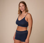 Angled front view of Sonnie wearing the Cloud Cotton Triangle Bralette and Cloud Cotton Highwaist Boyshort in Midnight. The low v-neck neckline and supportive underband of the bralette are emphasized. 