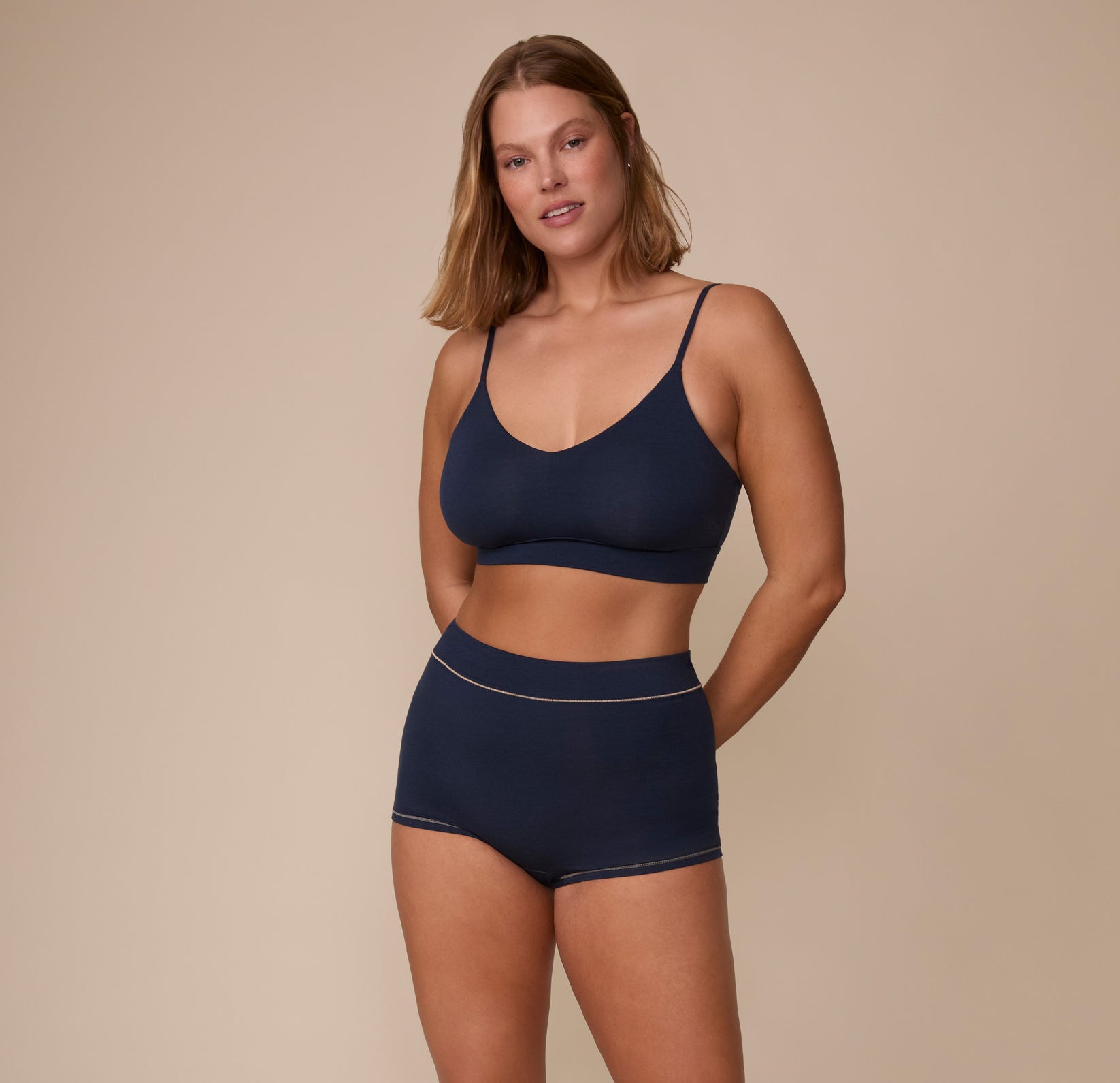 Full body view of Sonnie wearing the Cloud Cotton Triangle Bralette and Cloud Cotton Highwaist Boyshort in Midnight. The comfortable cotton-modal fabric of the matching set is emphasized.