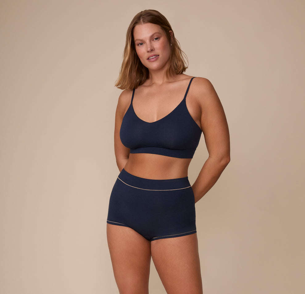 Full body view of Sonnie wearing the Cloud Cotton Triangle Bralette and Cloud Cotton Highwaist Boyshort in Midnight. The comfortable cotton-modal fabric of the matching set is emphasized.