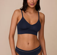 Marcela wearing the Cloud Cotton Triangle Bralette and Cloud Cotton Highwaist Thong in Midnight. The low v-neck neckline and thin straps are emphasized. sizing: Marcela wears size Small