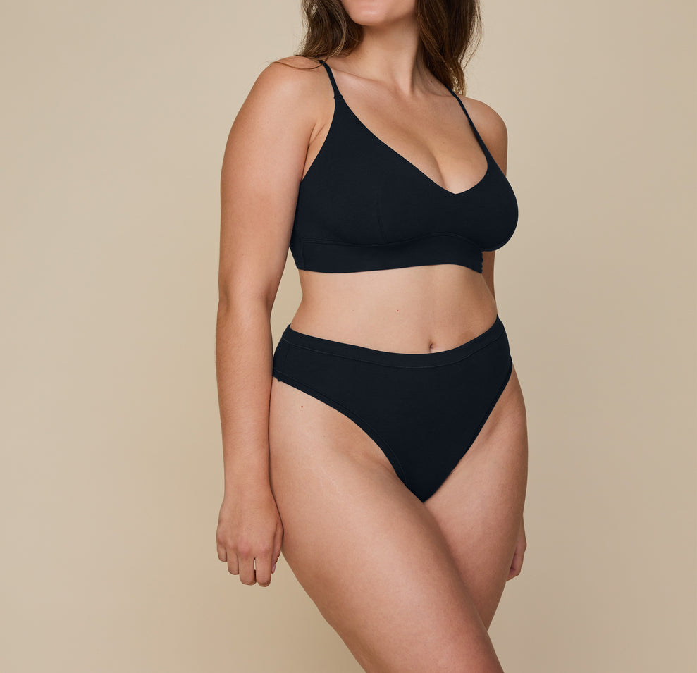 Detailed close-up of Summerlyn wearing the Cloud Cotton Highwaist Thong in Black, focusing on the soft fabric. sizing: Summerlyn wears size Large