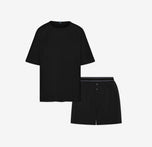 Flat lay of the Cloud Cotton Sleep Set in Black, featuring a short-sleeve tee with chest pocket and matching boxer-style sleep shorts. The shorts have a button fly and tonal waistband with a thin black stripe detail. Displayed against a white background for a clean, minimal presentation.
