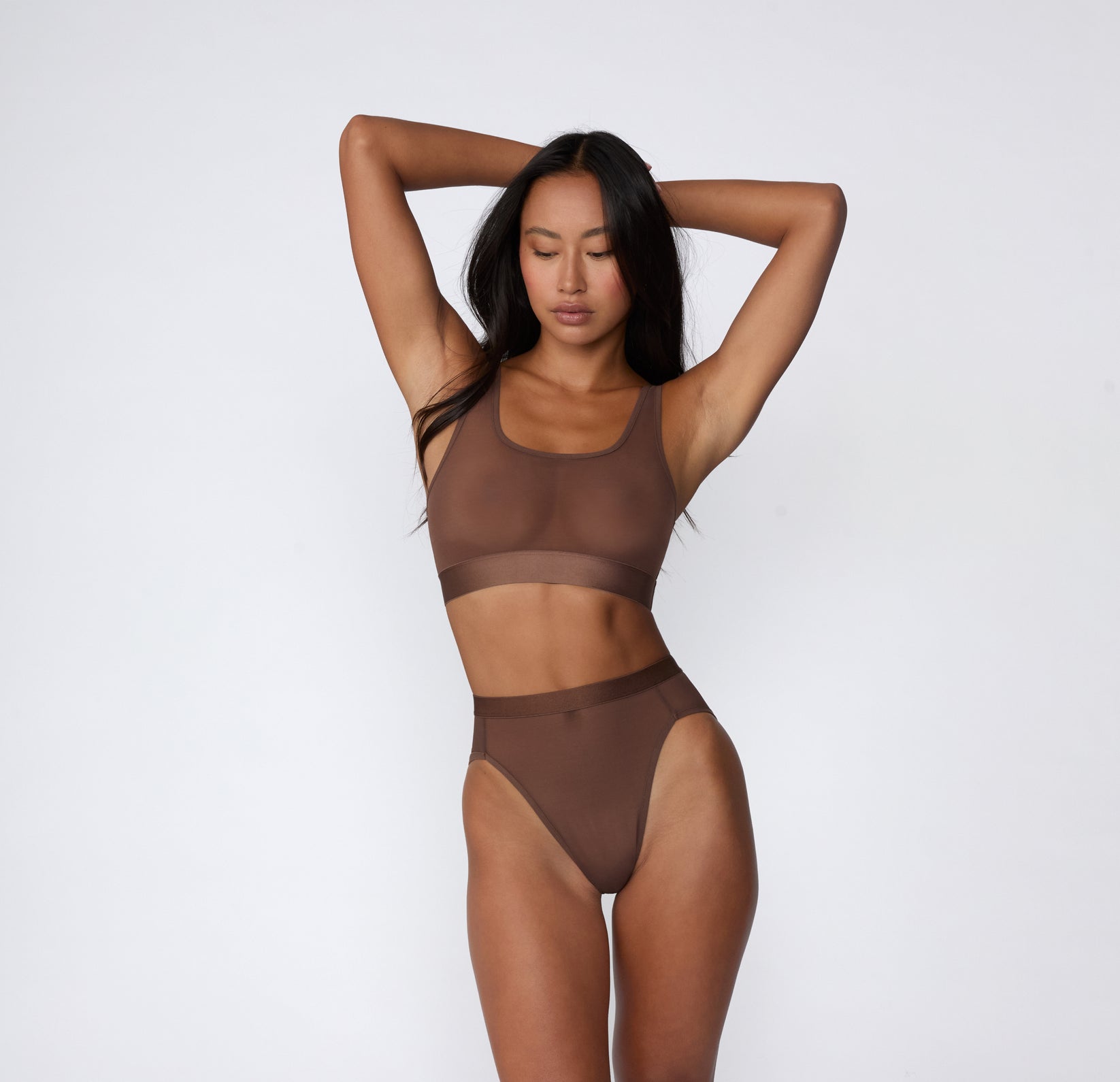 On a white studio backdrop, a full-body view shows Amber wearing the ComfortMesh™ Highwaist in Cashmere with the matching bralette, highlighting the sheer mesh fabric, high-rise coverage, and smooth waistband.