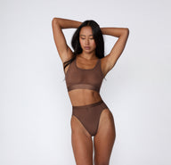 On a white studio backdrop, a full-body view shows Amber wearing the ComfortMesh™ Highwaist in Cashmere with the matching bralette, highlighting the sheer mesh fabric, high-rise coverage, and smooth waistband.